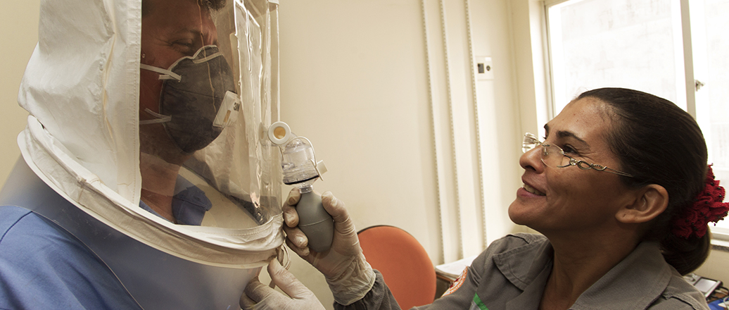 Frau zieht Mann einen Schutzanzug an