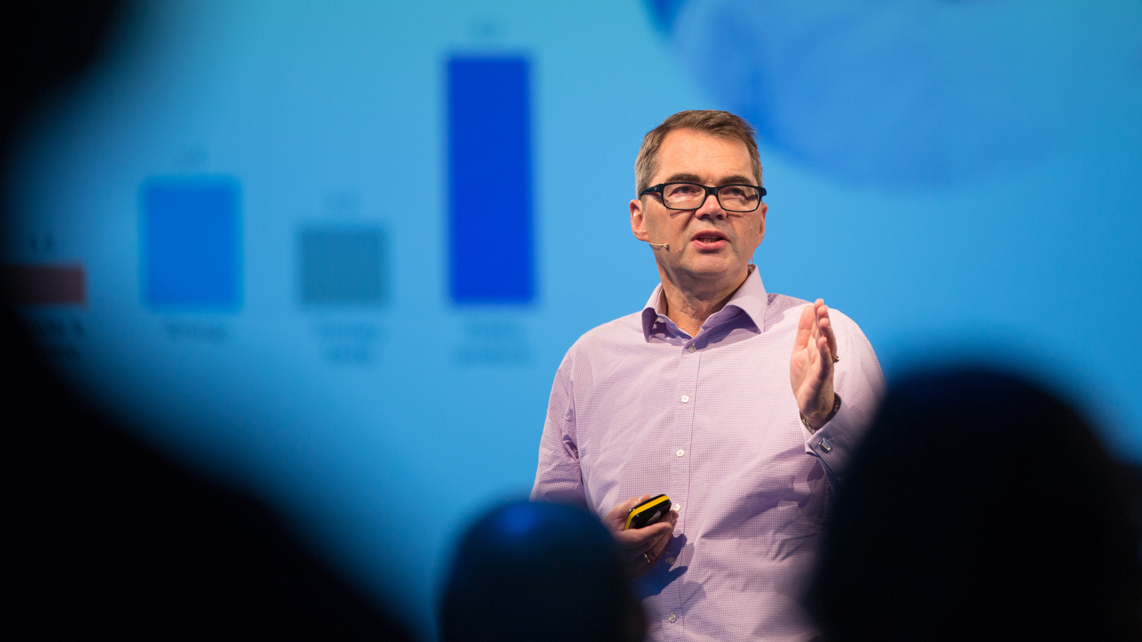 a man speaking in front of a blue screen