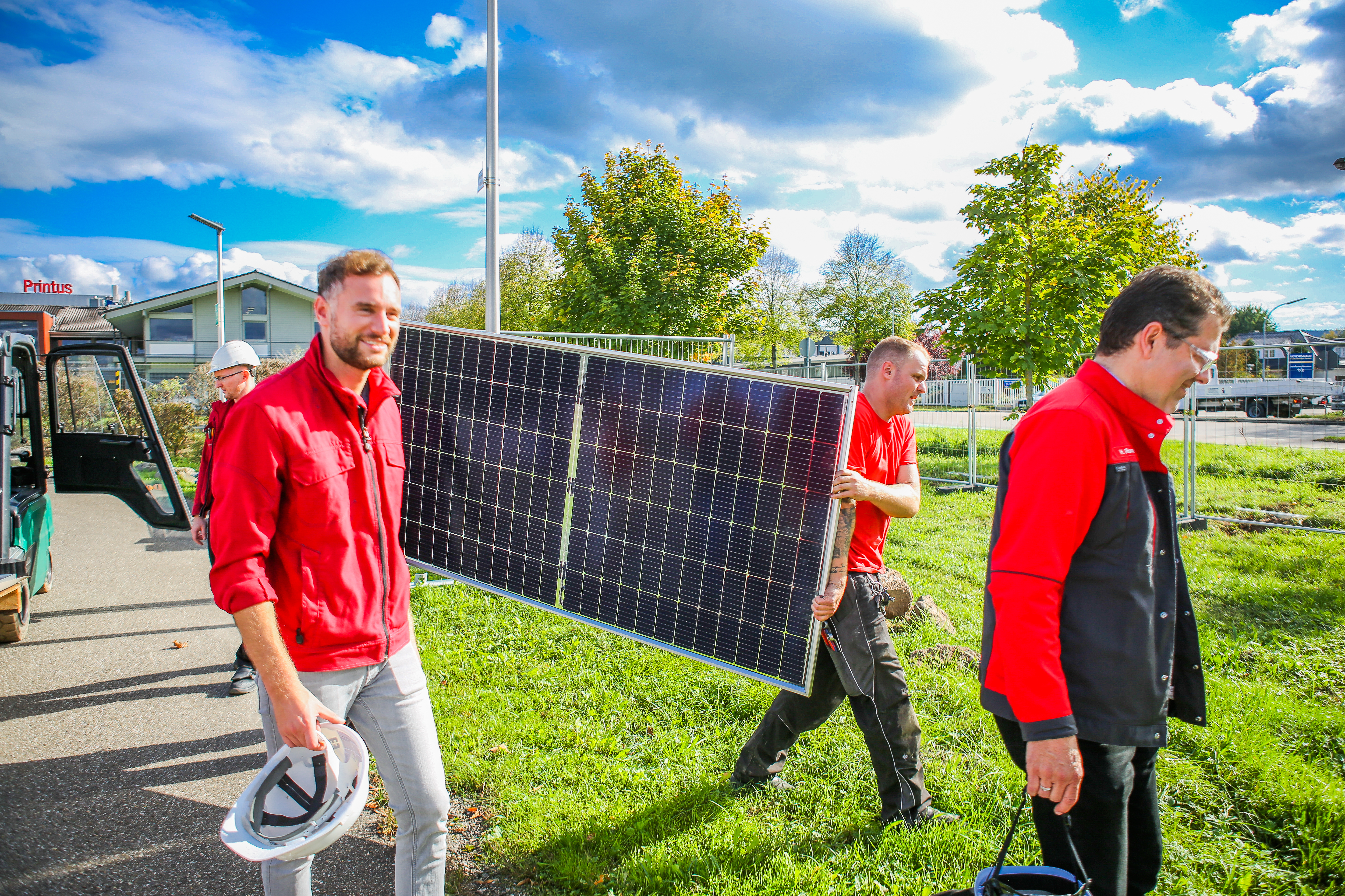 Hydro Mitarbeiter tragen Solarpanel für Solarzaun in Offenburg