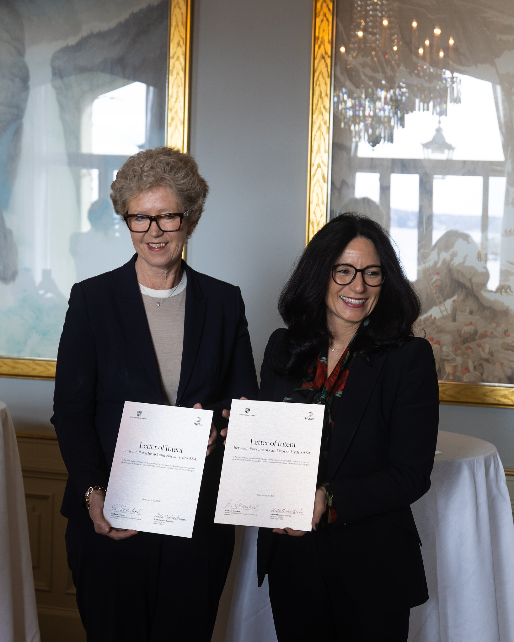 two woman holding papers