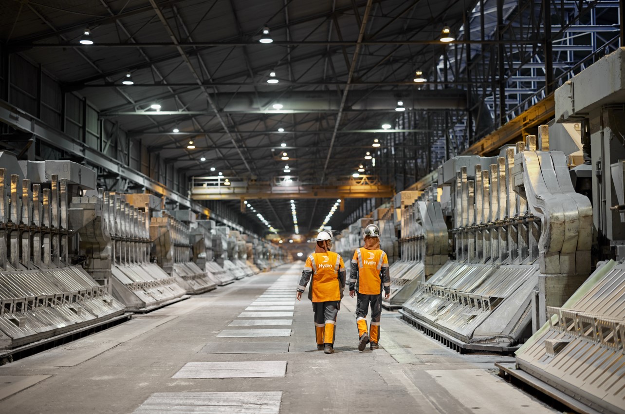 a few men in safety vests in a factory